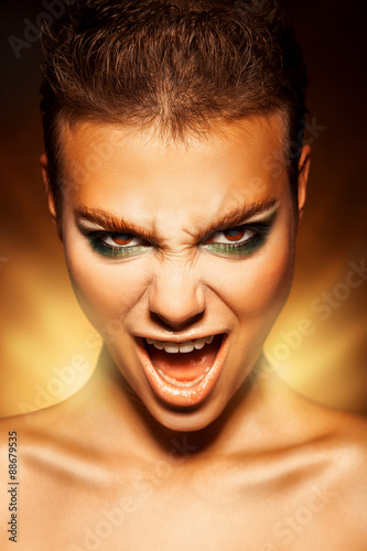 Angry young woman looking at camera and scream