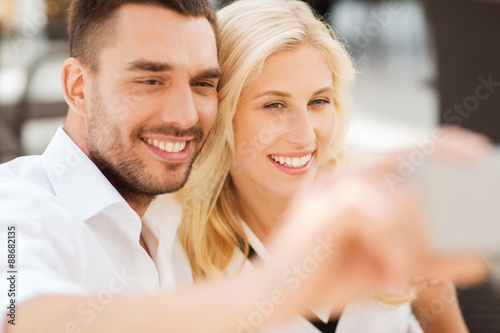 happy couple taking selfie with smatphone outdoors