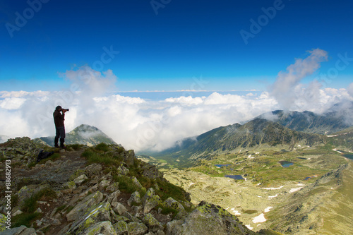 Man photographing a mountain lake