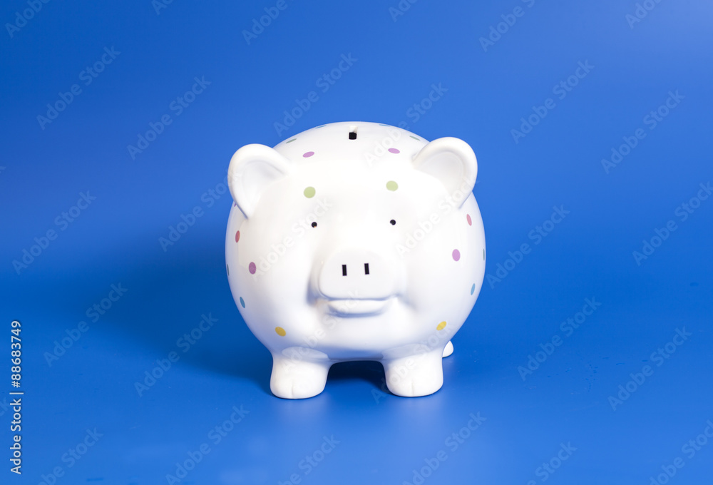 Pink piggy bank on blue background