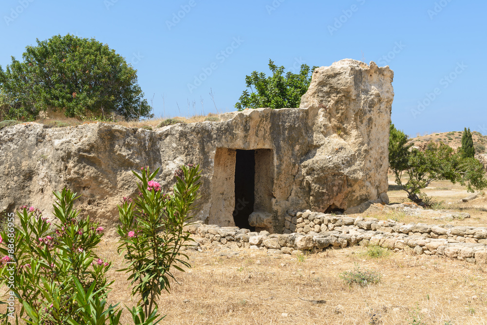 Entrance to an ancient stone burial tomb at an archaeological site in Paphos, Cyprus.