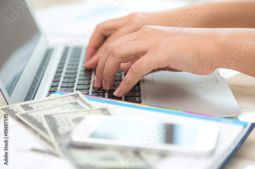 Business woman hand typing on laptop keyboard with Financial cha