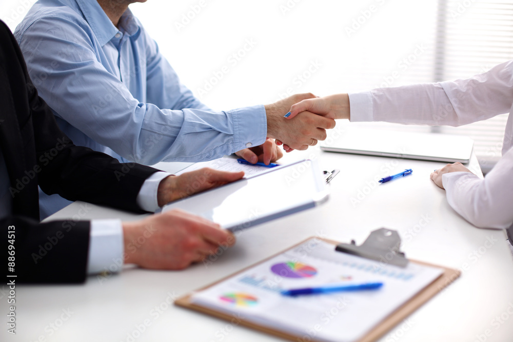 Business people handshake, sitting at the table Business people handshake, sitting at the table