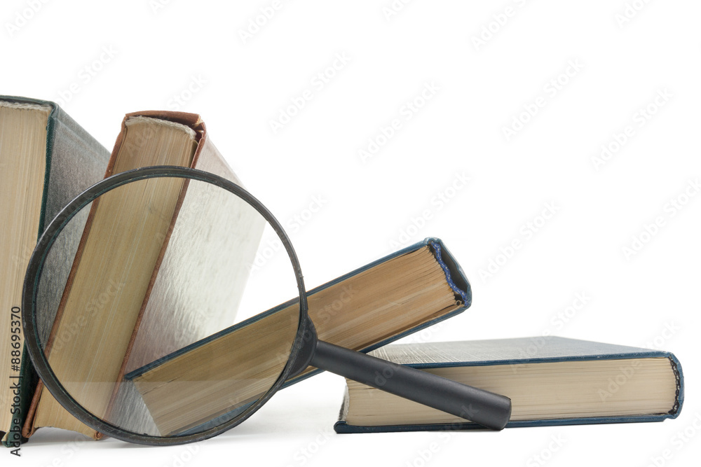 Stack of books with magnifying glass. Search information. Stack of books with magnifying glass. Search information.