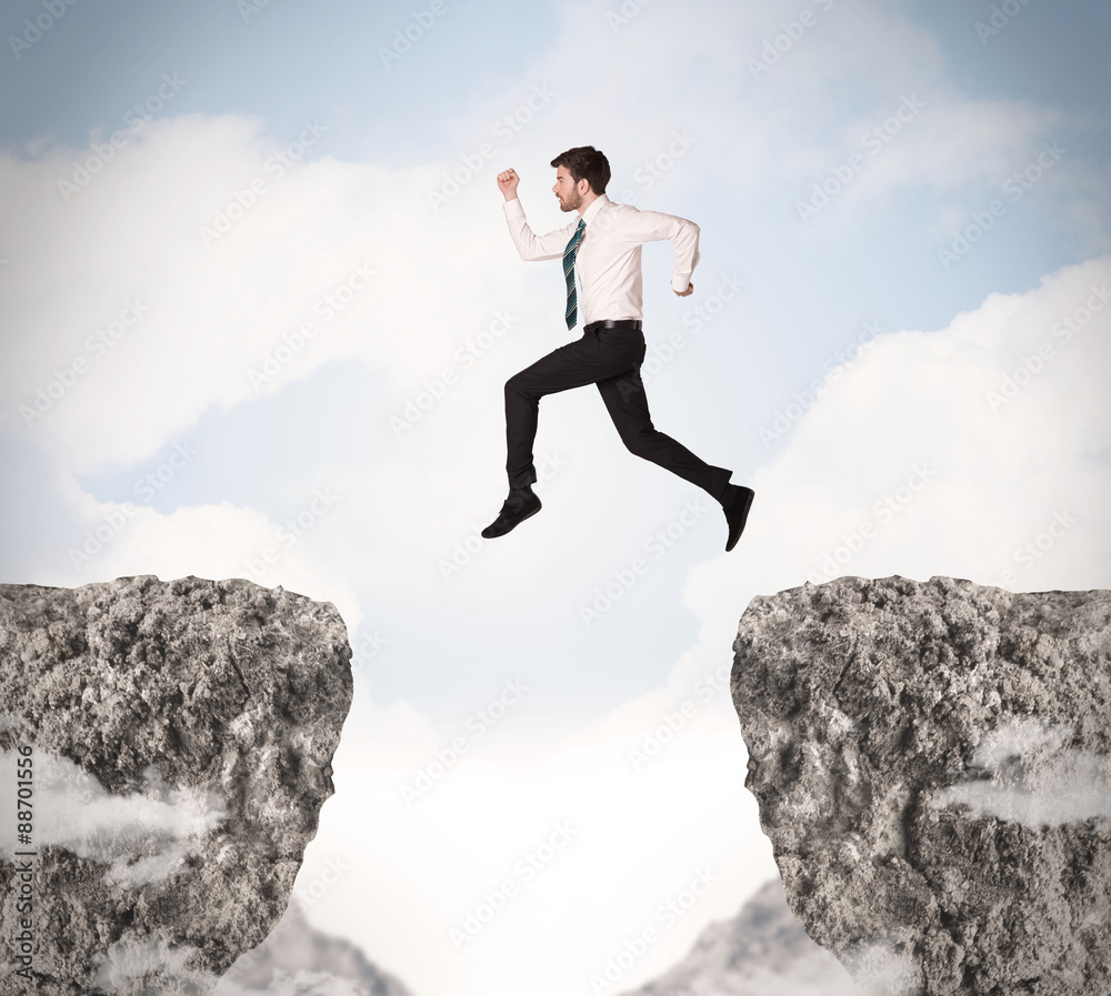 Funny business man jumping over rocks with gap Funny business man jumping over rocks with gap