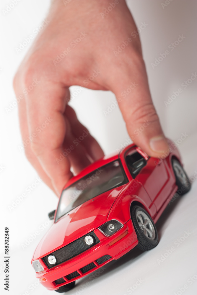 Close-up of a man's hand with a red car