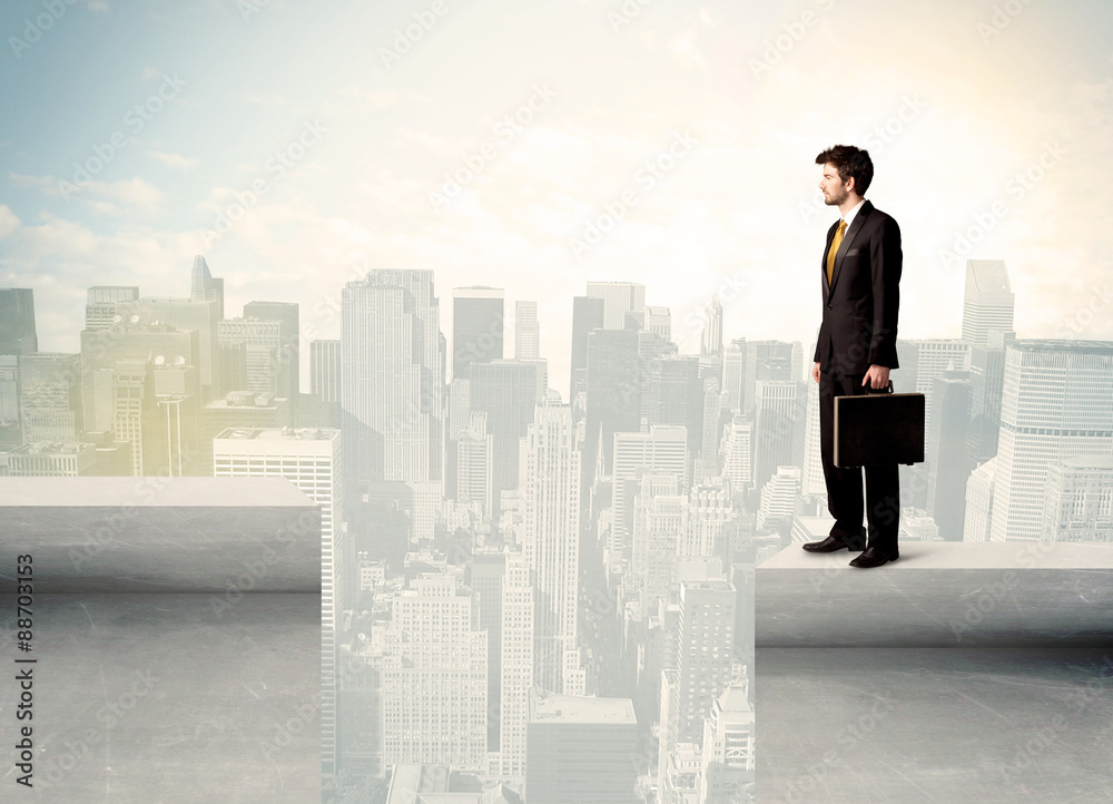 Businessman standing on the edge of rooftop Businessman standing on the edge of rooftop