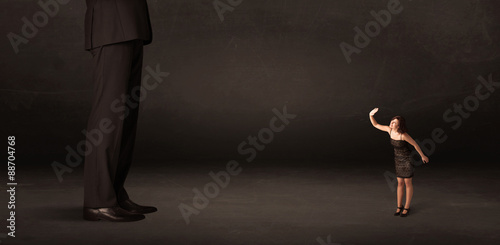 Huge man with small businesswoman standing at front concept