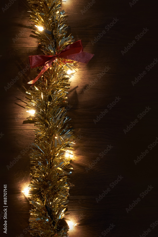 Traditional Christmas Tree lights and tinsel lying on a wooden