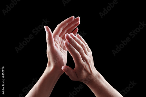 Fototapeta beautiful female hands isolated on black background applause