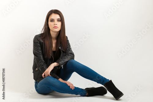 Portrait of sitting young calm beautiful brunette woman posing for model tests against white background © sergeyzapotylok