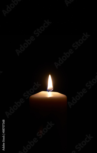White candle on a dark wooden floor.