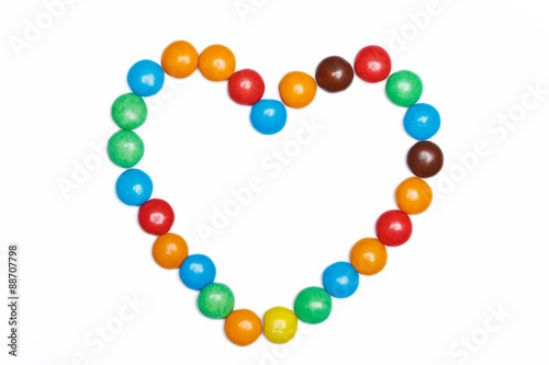 heart frame of colorful candy on a white background with space f