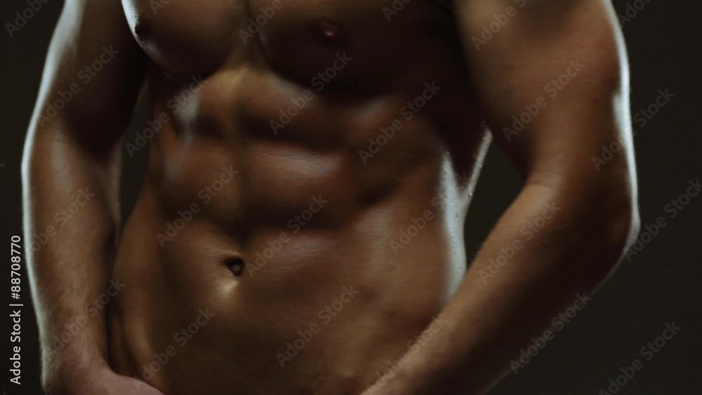 Young man showing work of muscles of body - abs Young man showing work of muscles of body - abs