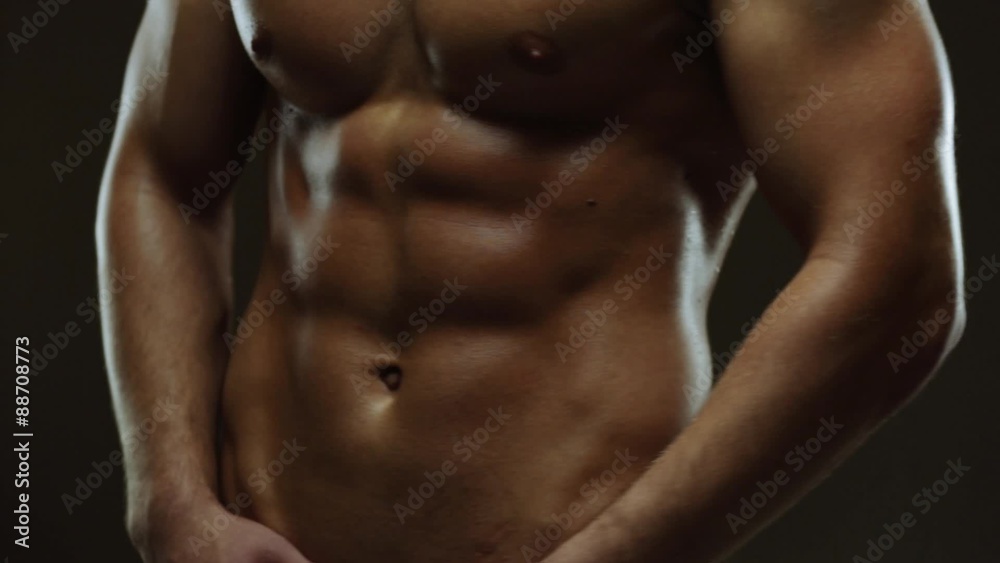 Young man showing work of muscles of body - abs Young man showing work of muscles of body - abs