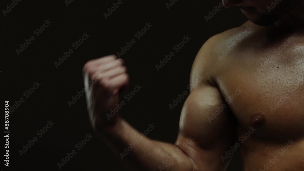 Young man showing work of muscles of body - biceps