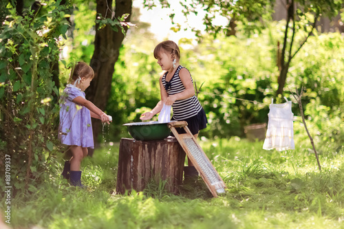little helper girls sisters washes clothes using the washboard o
