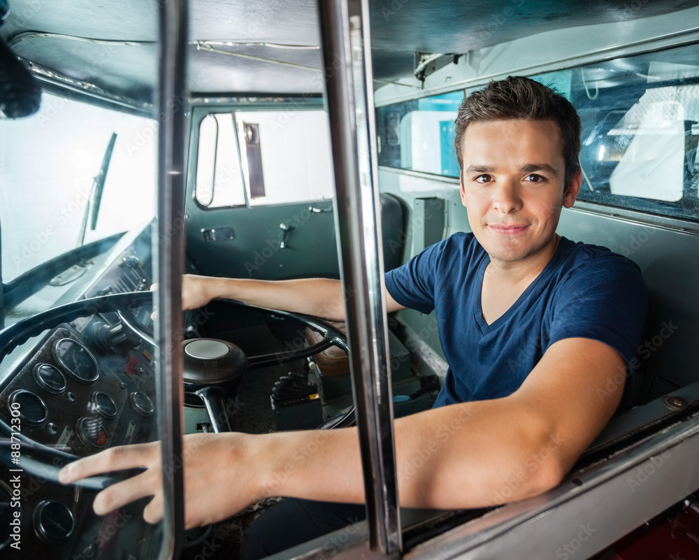 Fototapeta premium Confident Firefighter Driving Firetruck