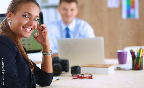 Female photographer sitting on the desk with laptop