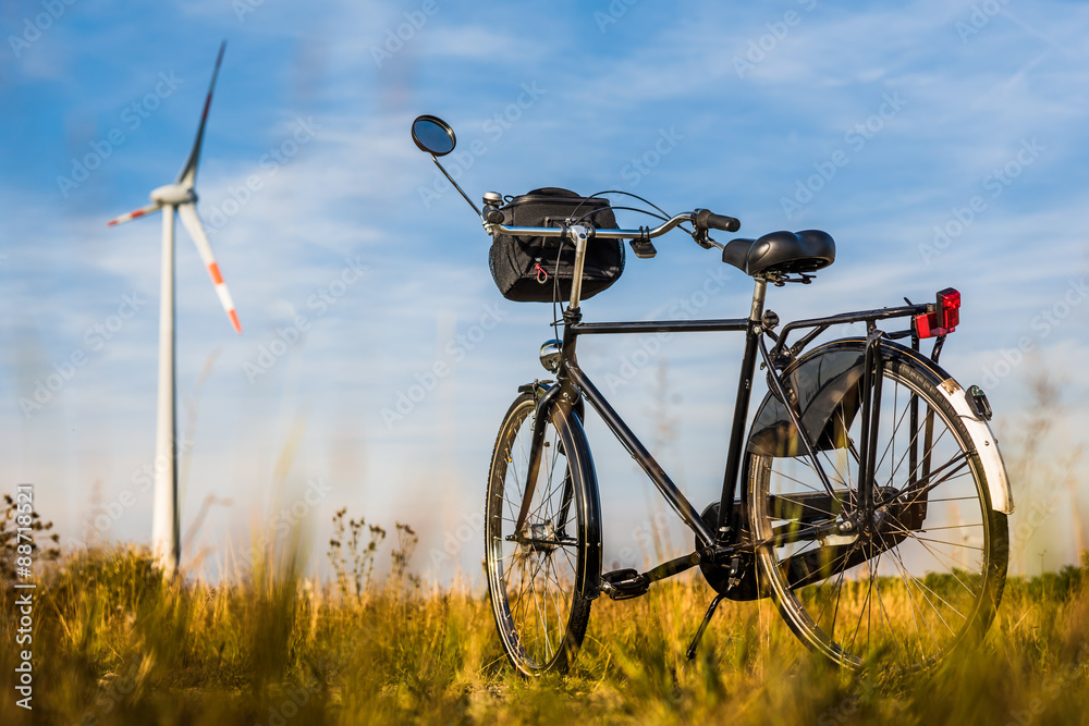 Fahrrad auf einer Wiese mit Windkraftanlage im Hintergrund