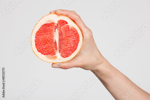 Female hand holding a ripe cutting grapefruit