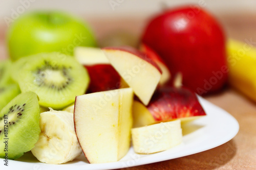 Fresh raw whole and sliced apple and kiwi close up