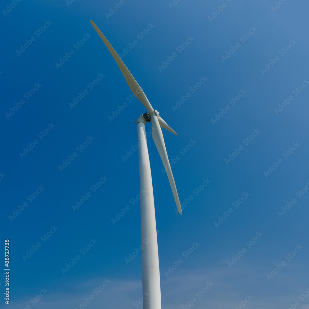 White wind turbines generating electricity on blue sky White wind turbines generating electricity on blue sky