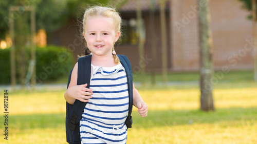 Schoolgirl Returning to school after the holidays, smiling and c