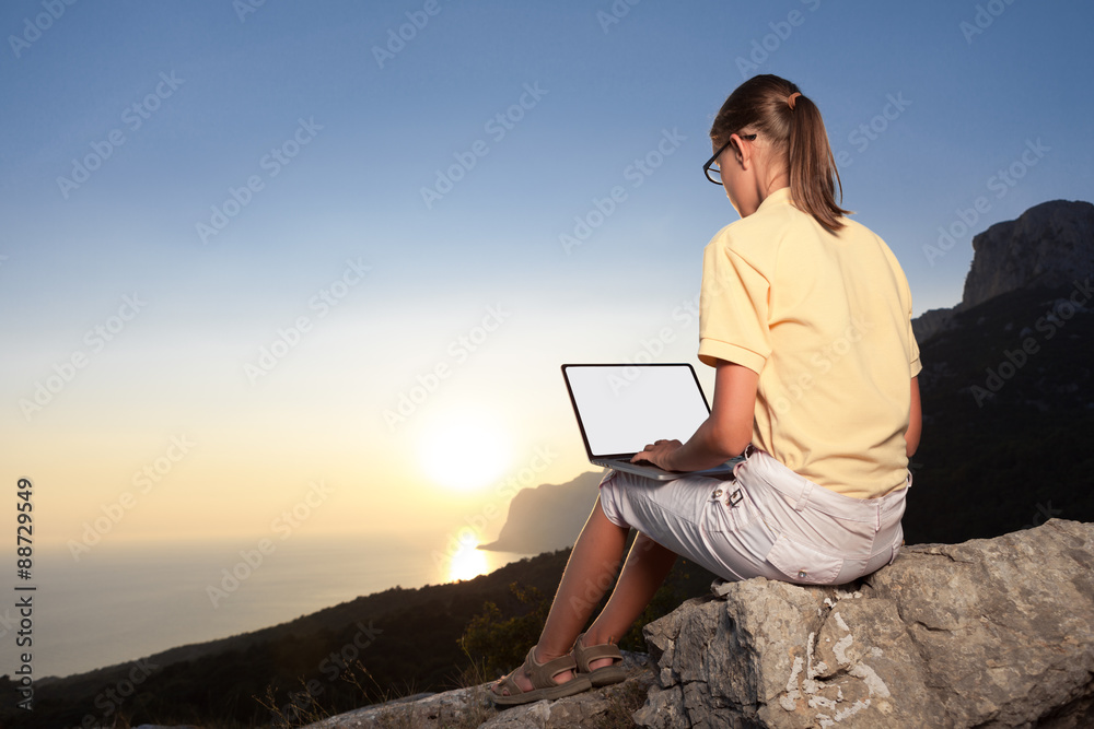 Woman working with laptop on mountain