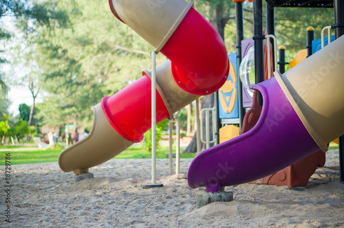 Red and violet pipe slides on modern kids playground
