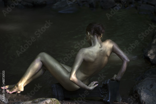 Gold woman near water