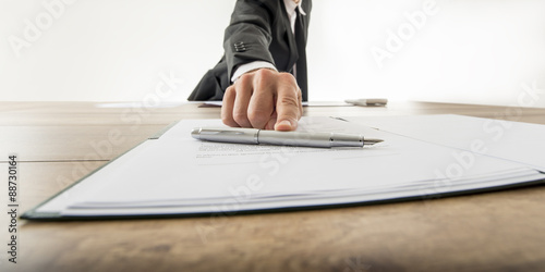 Front view of a businessman offering you to sign a document or c photo