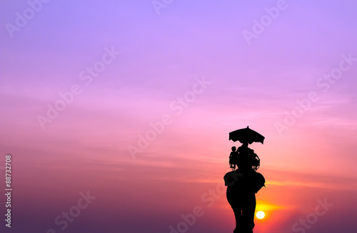 silhouette elephant with tourist at sunset