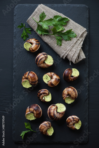Stone slate plate with uncooked escargots de bourgogne, top view