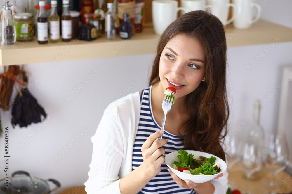 Young woman eating salad and holding a mixed salad Young woman eating salad and holding a mixed salad