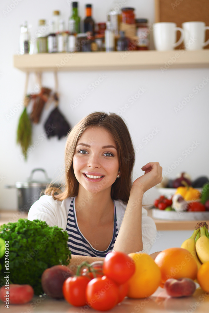 Young woman standing near desk in the kitchen