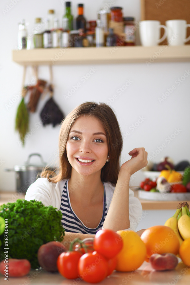 Young woman standing near desk in the kitchen Young woman standing near desk in the kitchen