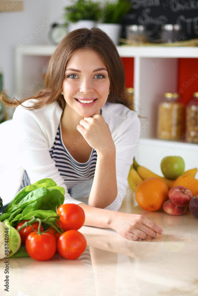 Young woman standing near desk in the kitchen Young woman standing near desk in the kitchen