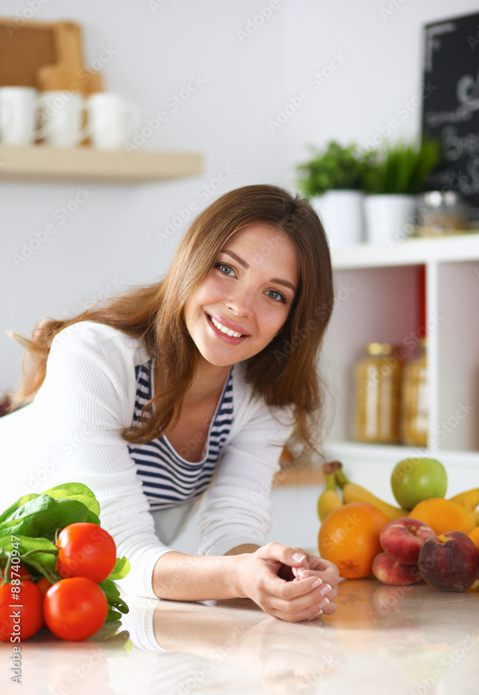 Young woman standing near desk in the kitchen Young woman standing near desk in the kitchen