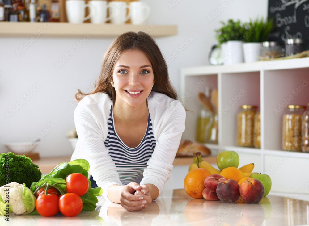 Young woman standing near desk in the kitchen Young woman standing near desk in the kitchen