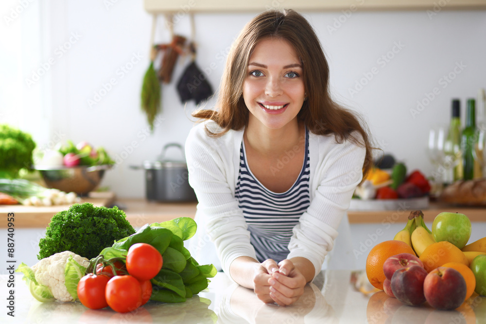 Young woman standing near desk in the kitchen Young woman standing near desk in the kitchen