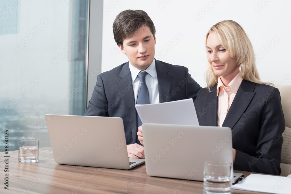 Business couple is double checking some essential business information. Panoramic office. Business couple is double checking some essential business information. Panoramic office.