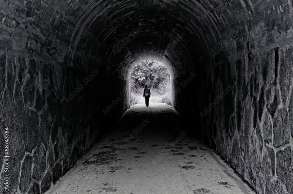 Mujer atravesando un túnel en blanco y negro