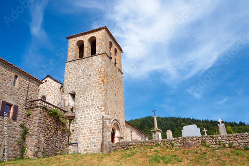 Medieval church with a bell tower and cemetery in France.
