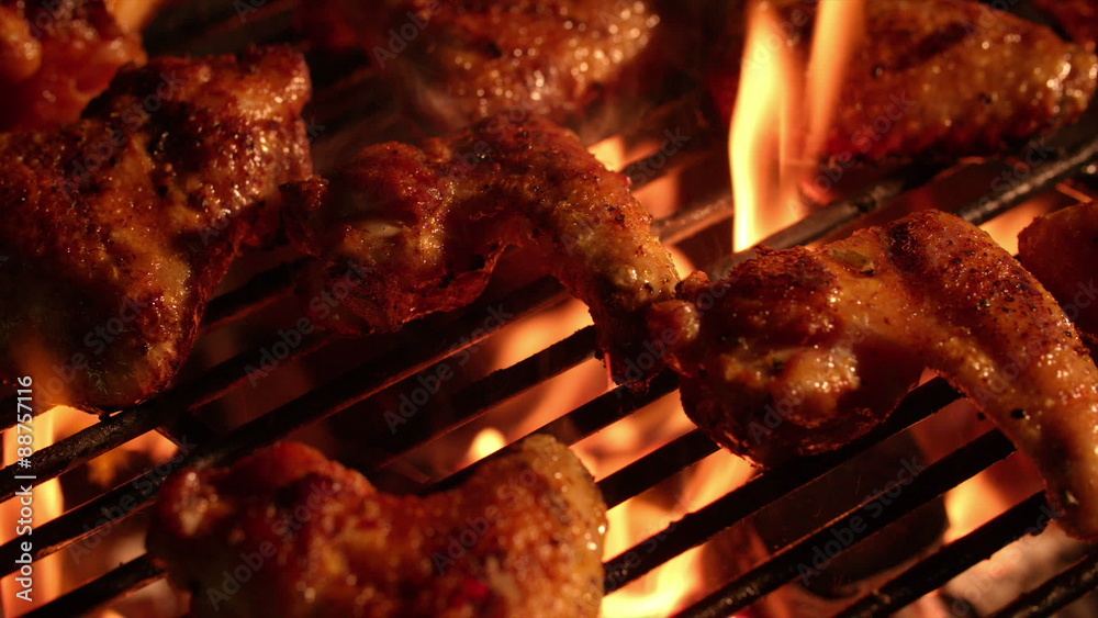 Spicy chicken wings grilling over glowing coals of a barbecue