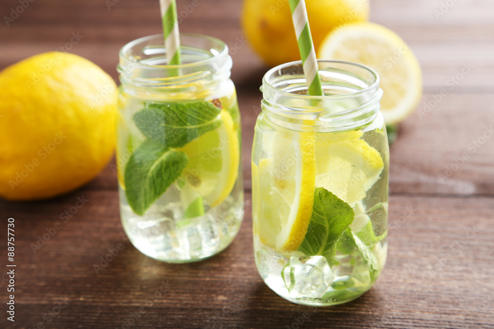 Fresh lemonade with lemon on brown wooden background Fresh lemonade with lemon on brown wooden background