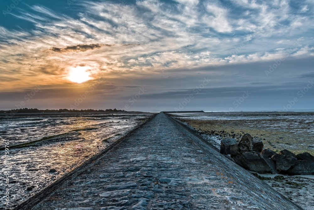 soleil et grande jetée en pierres