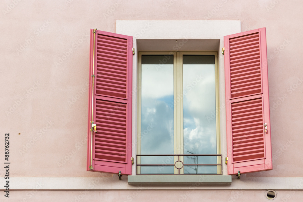 Fototapeta premium Iron grating window with red shutters