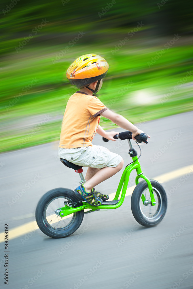 Naklejka premium Little boy riding a bicycle