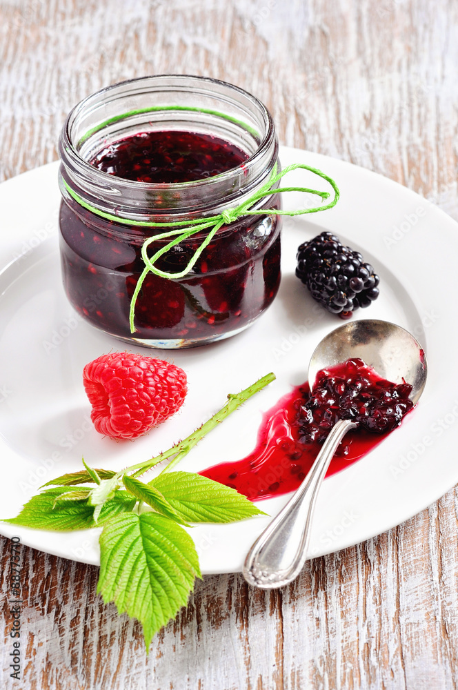 Homemade blackberry and raspberry jam in jars and fresh berries, selective focus Homemade blackberry and raspberry jam in jars and fresh berries, selective focus